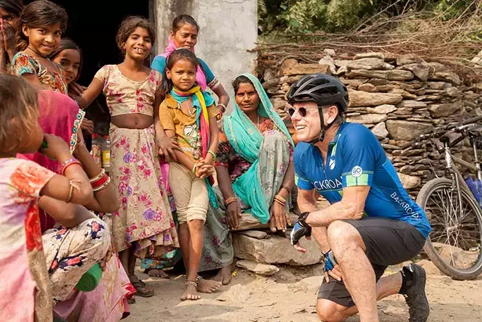 Bicyclist greeting local villagers