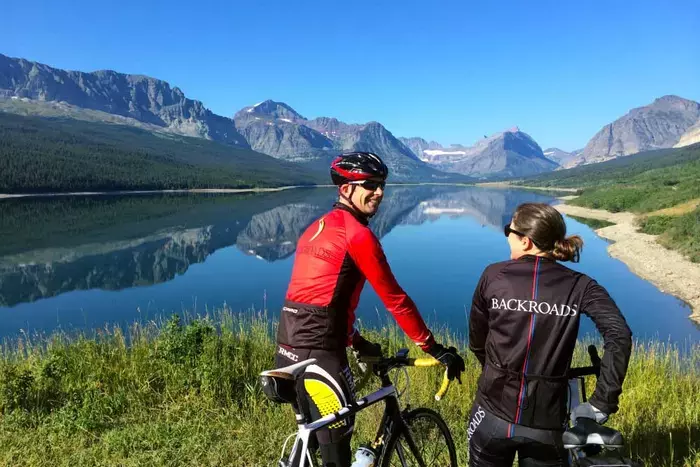 A couple biking along a Glacier Lake