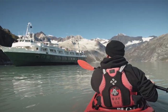 Kayaker approaching a small cruise ship