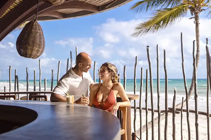 A couple at a beachside bar at Secrets