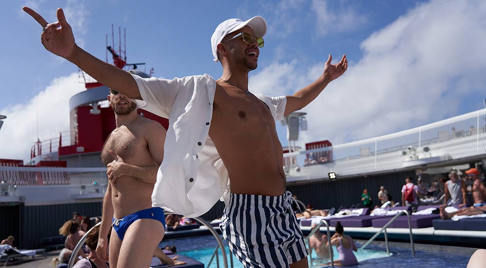 Two guys at a pool on board a Virgin Voyage