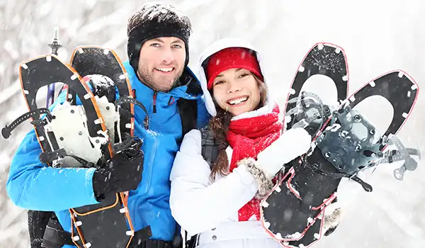 Couple smiling with snowshoes
