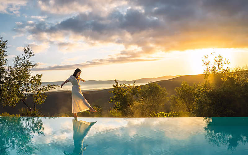 Lady walks along edge of infinity pool