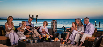 An extended family enjoying time on the beach, evening