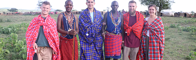 Four Americans standing with two Masaii men