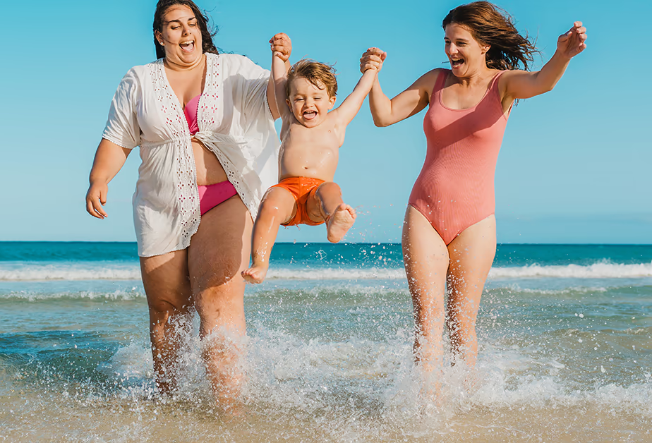Lesbian moms with child on the beach