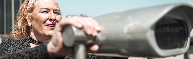 Trans woman looking through telescope