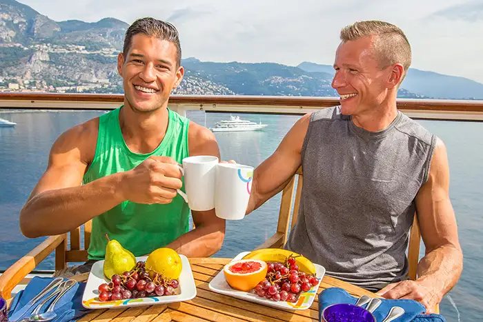 A male couple enjoys breakfast on a cruise ship
