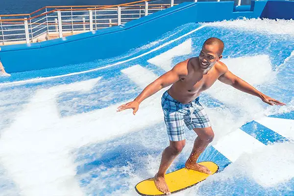 A main rides the Flow Rider Surf Simulator on a Royal Caribbean ship