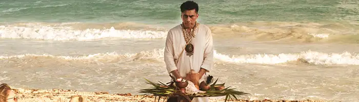 A Shaman leads a meditation session on the beach