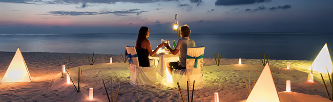 A couple shares a private romantic dinner on the beach